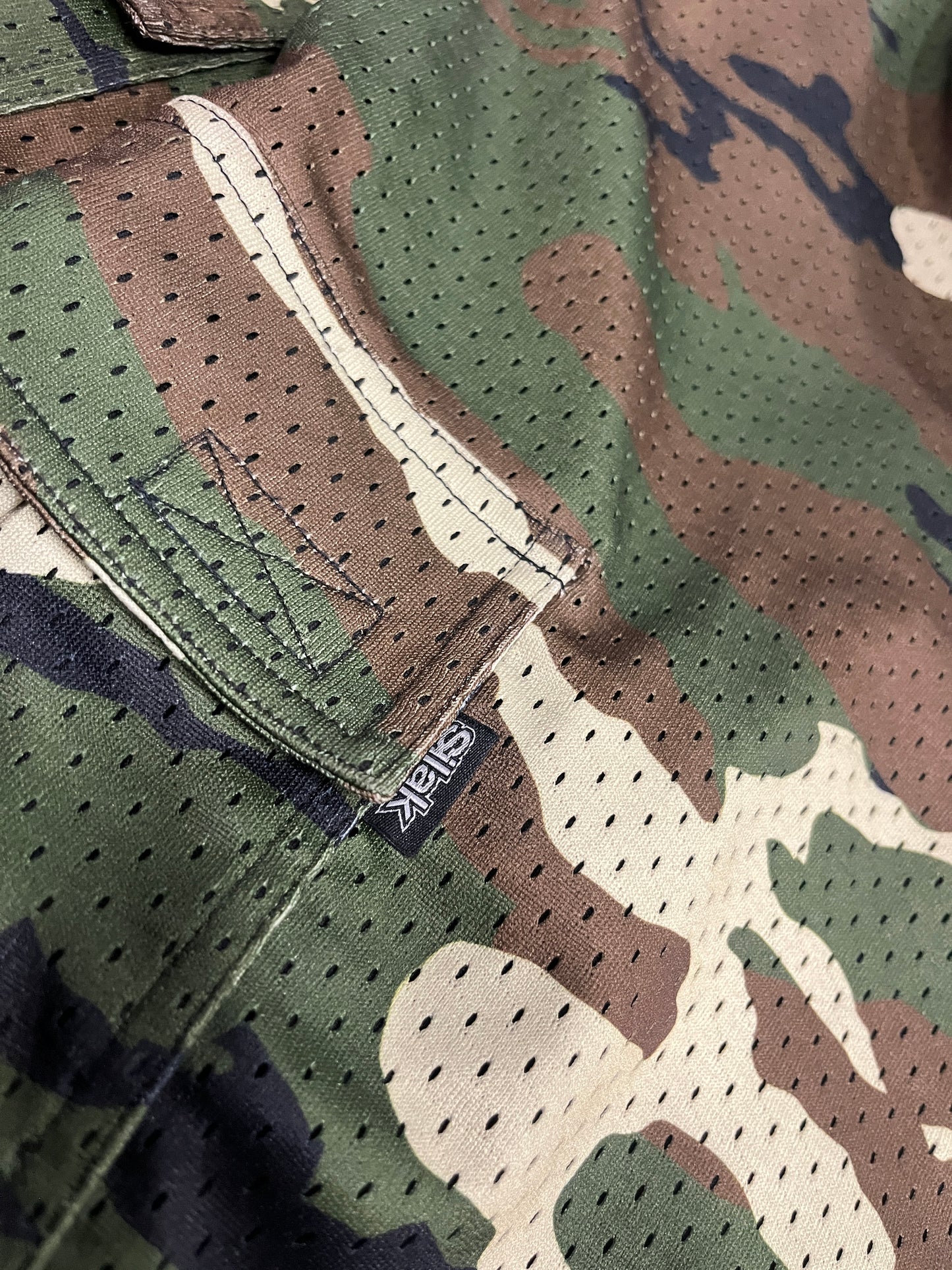 Close-up of camouflage fabric with a visible brand label.
