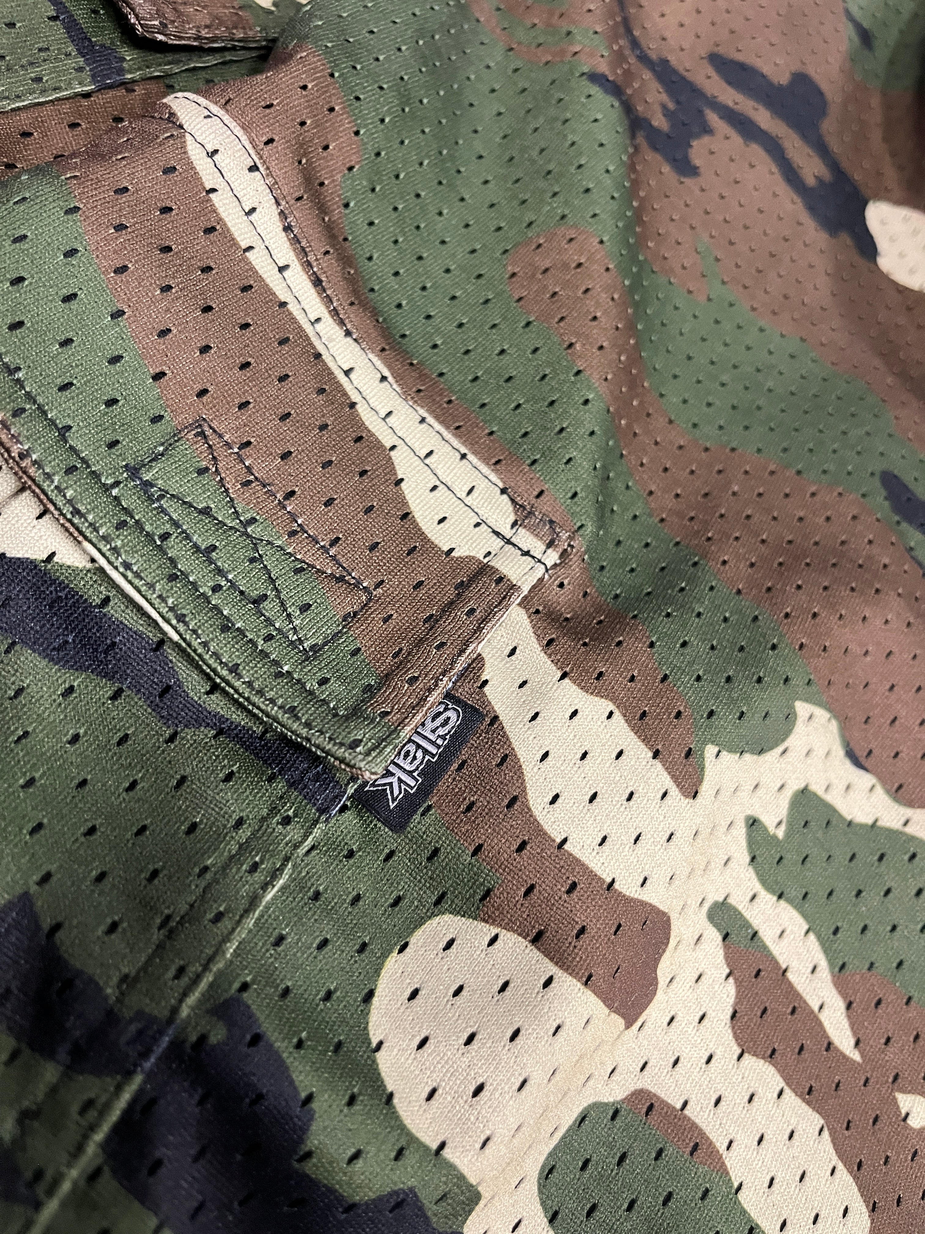 Close-up of camouflage fabric with a visible brand label.